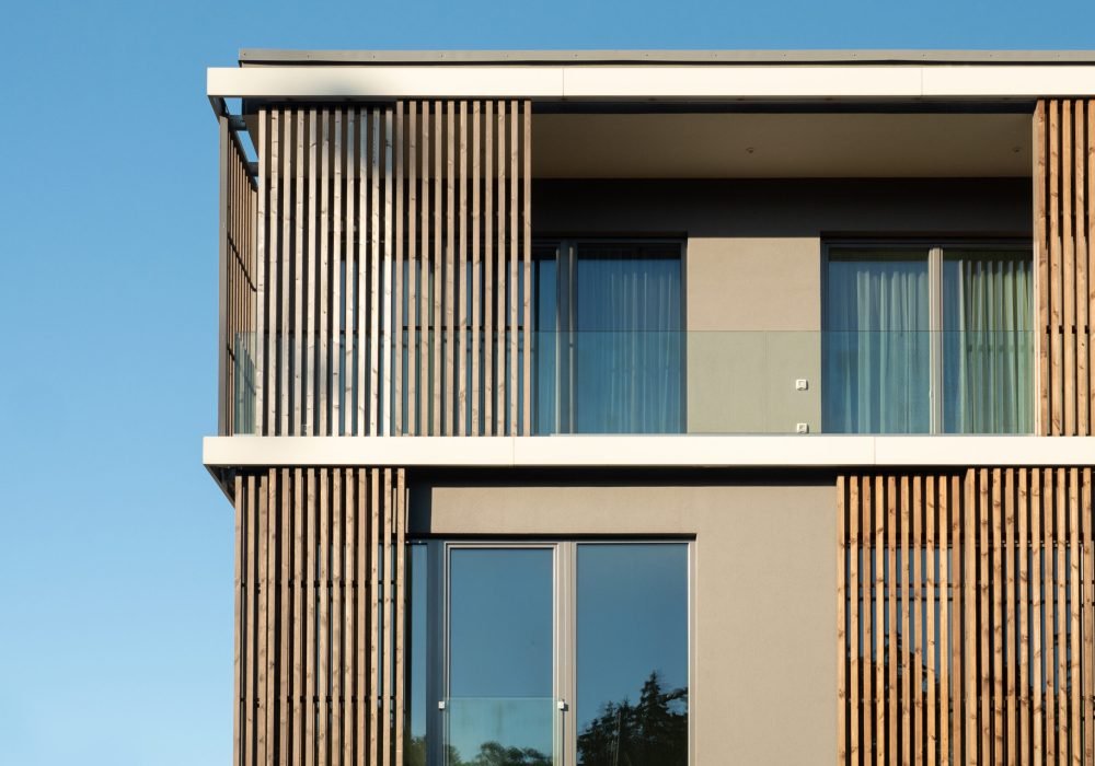 New modern residential building with balcony against blue sky. Housing construction concept. Elite residential building.
